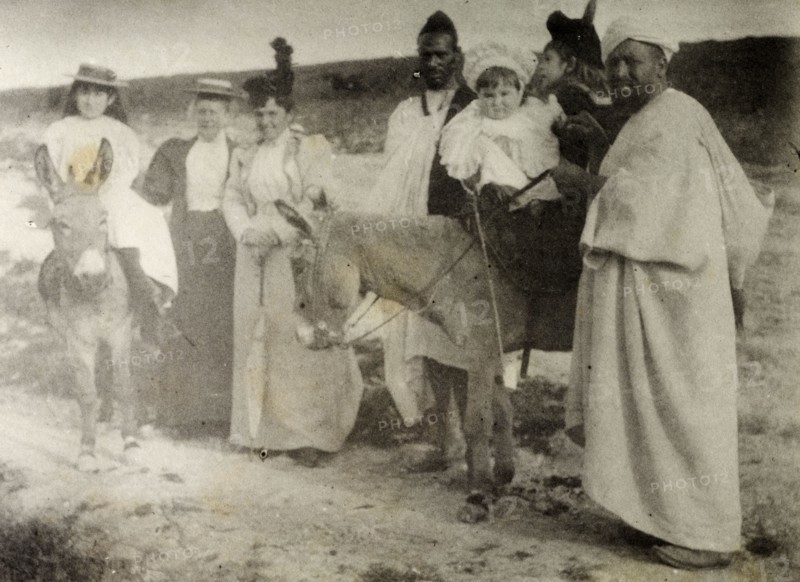 The Russi children on a donkey ride. A European governess and two Moroccan servants accompany Mrs Russi and her children on a donkey ride. The Europeans all wear typical Victorian dress. Safi, Morocco, 1898. Safi, Safi, Morocco, Northern Africa, Africa.