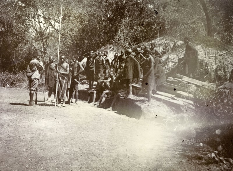 Kenyan 'road-makers'. A group of Kenyan men await instructions. They wear traditional dress and are captioned as 'Road makers'. British East Africa (Kenya), 1906. Kenya, Eastern Africa, Africa.