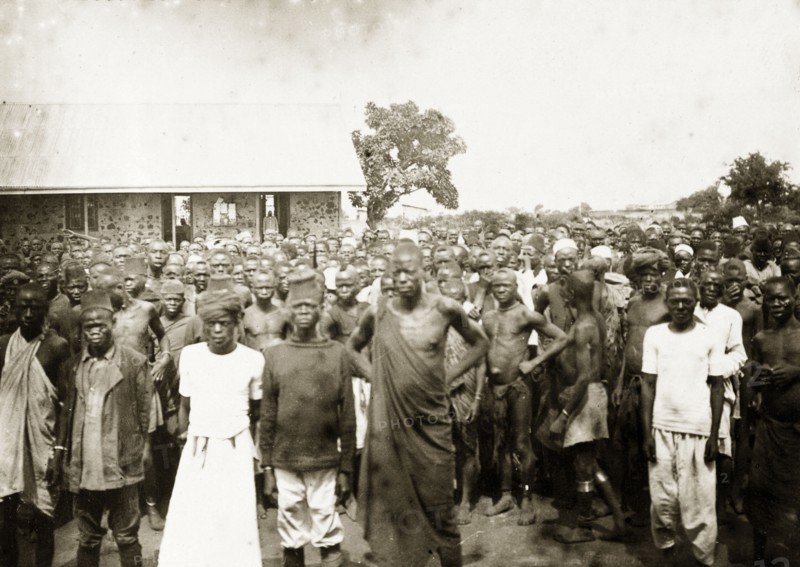 African workers on strike, Kisumu. A large crowd of African men and women stands outside a European-style masonry building. A caption calls this the 'first strike in East Africa' and says that it was organized by Indians. Kisumu, British East Africa (Kenya), 1906. Kisumu, Nyanza, Kenya, Eastern Africa, Africa.
