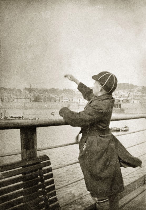 Charles Trotter on a pier. Charles Trotter, aged about 12 years old, throws pebbles into the sea from an English pier. South coast, England, circa 1935. England (United Kingdom), Western Europe, Europe .