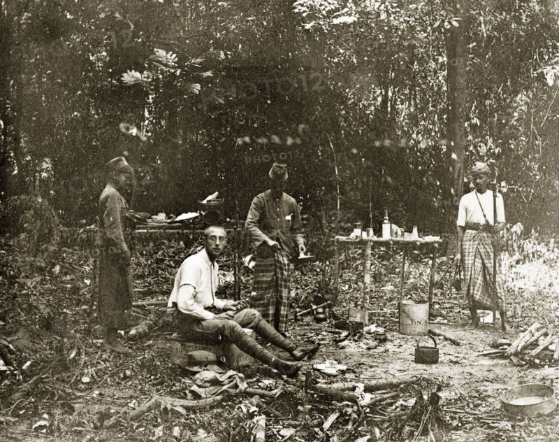 Sheffield's' jungle camp, Malaysia. Sheffield', a member of a British-led trigonometrical survey team, and his Malayan assistants stop for a meal in the jungle. Upper Perak, British Malaya (Malaysia), circa 1902., Perak, Malaysia, South East Asia, Asia.