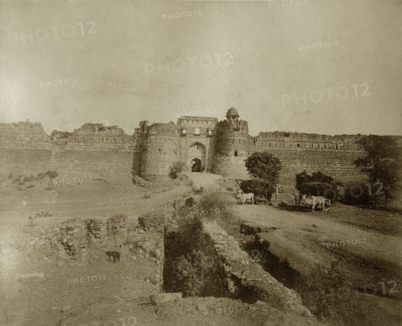 Ruined walls in Delhi. Cattle-drawn carts laden with hay stand outside the ruined walls in an old part of the city. Delhi, India, circa 1885. Delhi, Delhi, India, Southern Asia, Asia.