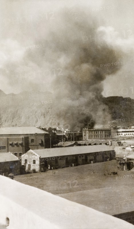 Riot damage in Aden, 1947. A large plume of smoke billows from a building in the Jewish quarter of Aden, during the Arab riots that took place between 1-3 December 1947 in response to the United Nations Partition Plan for Palestine. Aden, Yemen, December 1947. Aden, Adan, Yemen, Middle East, Asia.