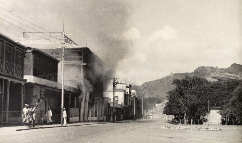 Riot damage in Aden, 1947. Smoke billows from a building in the Jewish quarter of Aden, during the Arab riots that took place between 1-3 December 1947 in response to the United Nations Partition Plan for Palestine. Aden, Yemen, December 1947. Aden, Adan, Yemen, Middle East, Asia.