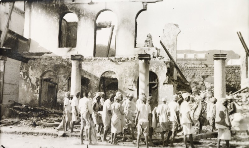 Aftermath of Arab riots in Aden, 1947. A crowd of men gather outside a gutted building in the Jewish quarter of Aden, after the Arab riots that took place between 1-3 December 1947 in response to the United Nations Partition Plan for Palestine. Aden, Yemen, December 1947. Aden, Adan, Yemen, Middle East, Asia.