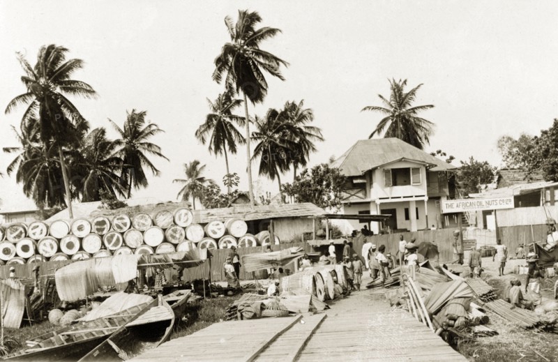 Palm oil storage yard. Barrels of palm oil wait to be collected by boat at a riverside storage yard belonging to the African Oil Nuts Company. Badagry, Lagos, Nigeria, 1924. Badagry, Lagos, Nigeria, Western Africa, Africa.