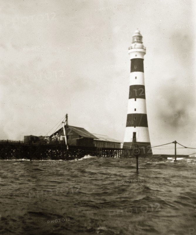 Alguada Reef lighthouse. The striped Alguada Reef lighthouse towers above rough sea waters in the Bay of Bengal. Burma (Myanmar), circa 1900. Burma (Myanmar), South East Asia, Asia.