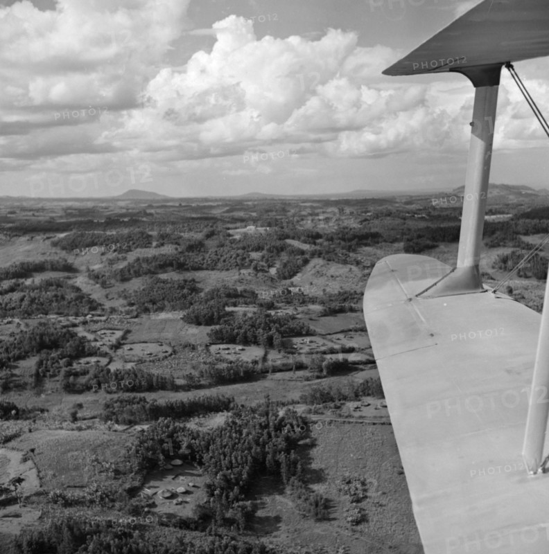 Kikuyu Reserve from the air. Aerial view taken from a Kenya Police Reserve (KPR) aircraft showing the patchwork of densely wooded terrain covering the slopes of the Kikuyu Reserve near Mount Kenya. Several Kikuyu villages are visible in clearings amongst the trees. Rift Valley, Kenya, 30 October 1952., Rift Valley, Kenya, Eastern Africa, Africa.