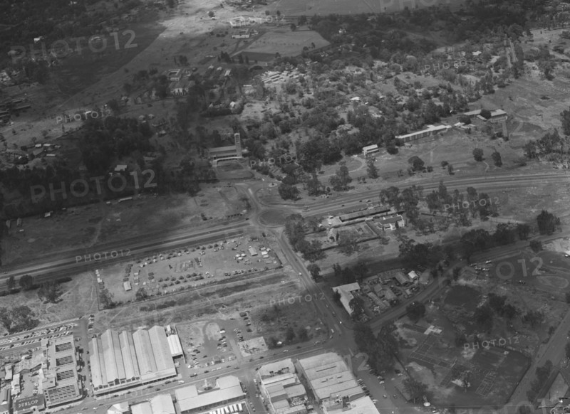 Air patrol over Littleton's town'. Aerial view taken from a patrol plane of a city identified by the photographer as 'Littleton's town'. This shot focuses on a large road intersected by a roundabout. Probably Kenya, 1 November 1952. Kenya, Eastern Africa, Africa.