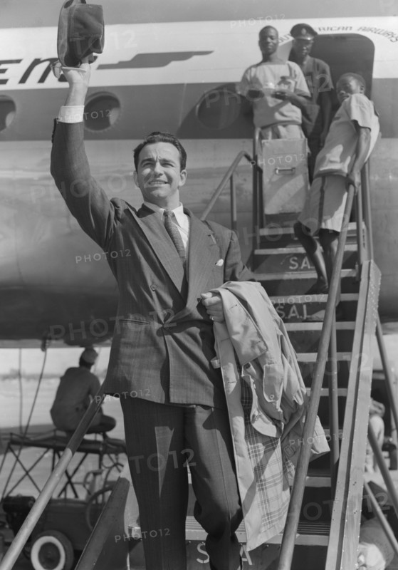 John Bentley arrives in Nairobi. Hollywood film star John Bentley waves his trilby hat as he disembarks from a plane at Eastleigh airport. Nairobi, Kenya, 9 November 1952. Nairobi, Nairobi Area, Kenya, Eastern Africa, Africa.