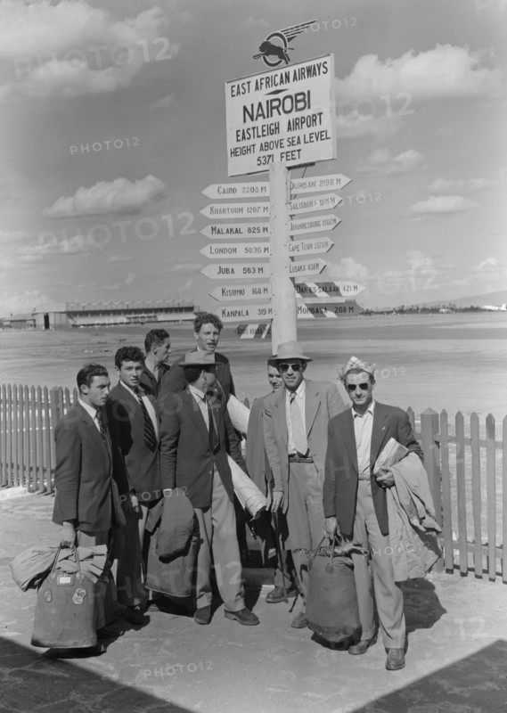 French athletics team. Members of a French athletics team pose beneath a signpost on their arrival at Eastleigh airport. Nairobi, Kenya, 9 November 1952. Nairobi, Nairobi Area, Kenya, Eastern Africa, Africa.