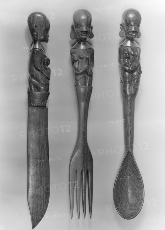 Carved wooden cutlery, Kenya. Three pieces of decorative wooden cutlery, including a knife, fork and spoon. The handles are intricately carved with the figure of a mother holding a baby. Kenya, 5 December 1952. Kenya, Eastern Africa, Africa.