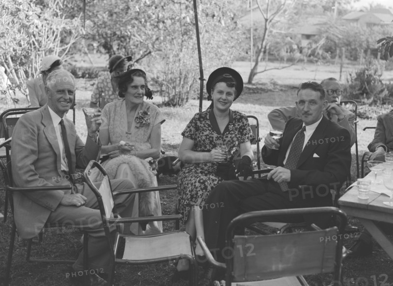 Guests at the Allen-Winter wedding. Guests at the Wendy Allen-Dudley Winter wedding relax with glasses of champagne in a sunny garden. Kenya, 30 December 1952. Kenya, Eastern Africa, Africa.