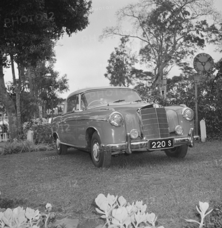 A shiny new Mercedes. A shiny new Mercedes car is displayed on a lawn bordered by flowers at the D.T. Dobie stand at the Royal Show. Kenya, 25 September 1957. Kenya, Eastern Africa, Africa.