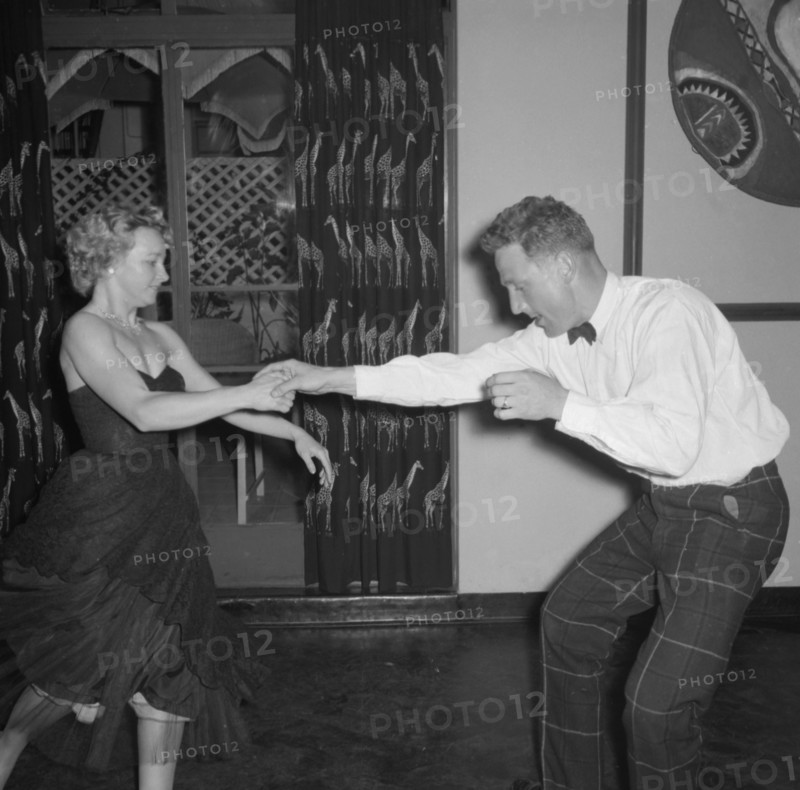 Dancing at the Equator Club. A couple dance energetically at the Equator Club. The woman, identifed as 'Wanda', wears a strapless dress that flares out as she dances. Nairobi, Kenya, 19 October 1957. Nairobi, Nairobi Area, Kenya, Eastern Africa, Africa.