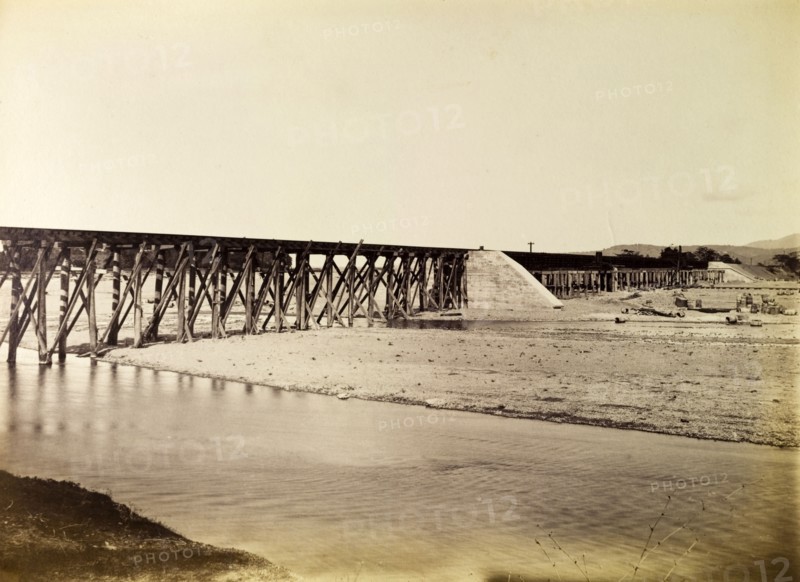 Port Antonio extension line. A narrow trestle bridge carries the Port Antonio railway extension line across a river. Portland, Jamaica, circa 1895., Portland, Jamaica, Caribbean, North America .