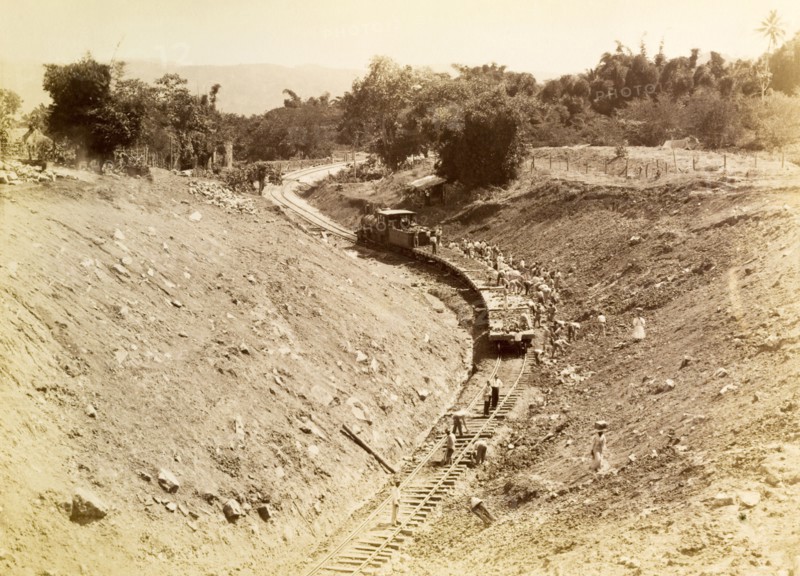 Rail track construction, Jamaica. Labourers at a railway construction site pile discarded rubble onto railway cars to taken away. Jamaica, circa 1895. Jamaica, Caribbean, North America .