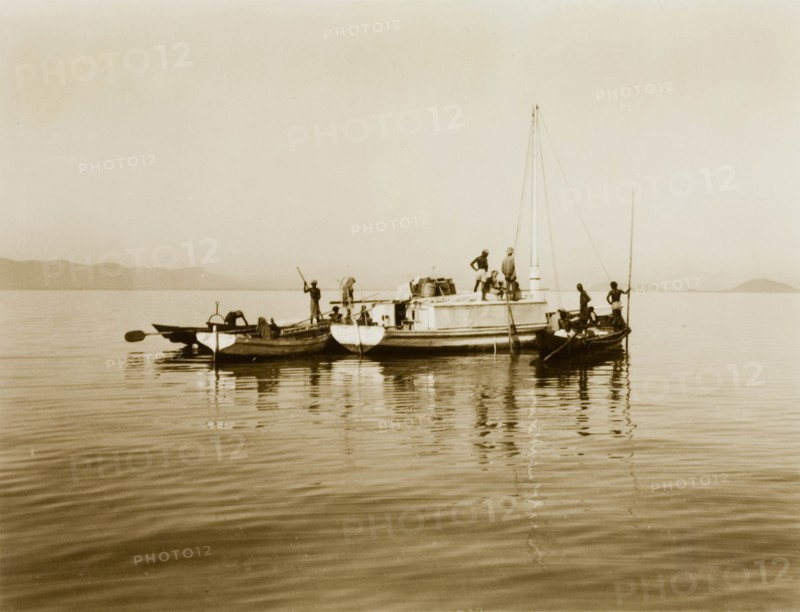 Boats on Chilka Lake. Three small boats, piloted by a team of men, float together on the calm waters of Chilka Lake. Orissa, India, circa 1940., Orissa, India, Southern Asia, Asia.