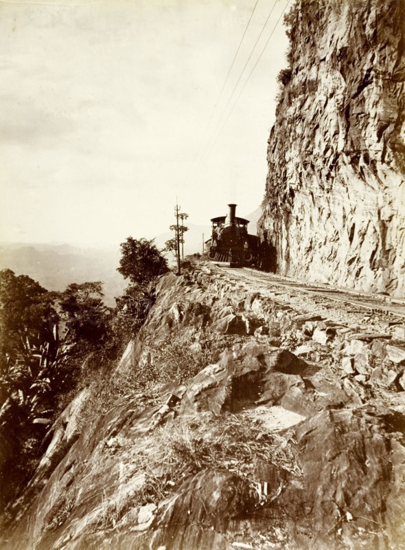 Steam train at 'Sensation Rock'. A steam locomotive rounds the corner of a mountain at 'Sensation Rock', a section of track running from Kandy to Colombo. On the left is a precipitous drop: on the right a sheer cliff. Cables run overhead and a telegraph pole is visible by the train. Near Balana, Ceylon (Sri Lanka), circa 1885., Central (Sri Lanka), Sri Lanka, Southern Asia, Asia.