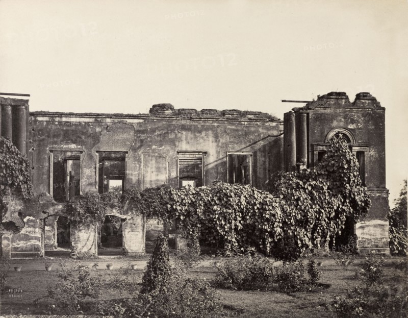Ruins of the British Residency. The British Residency at Lucknow, ruined during the Indian Mutiny of 1857-8. This view shows the ruins of the compound's once classical banqueting hall, partially overgrown with climbing plants. Tended lawns and flowerbeds are visible in the foreground. Lucknow, North Western Provinces (Uttar Pradesh), India, circa 1880. Lucknow, Uttar Pradesh, India, Southern Asia, Asia.