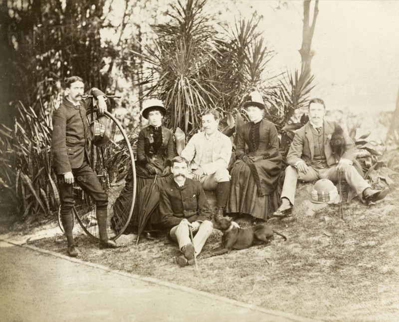 Relaxing in Eden Gardens. Group portrait of four European men and two women relaxing in Eden Gardens. The man on the left stands with a penny-farthing bicycle. Calcutta (Kolkata), India, circa 1885. Kolkata, West Bengal, India, Southern Asia, Asia.