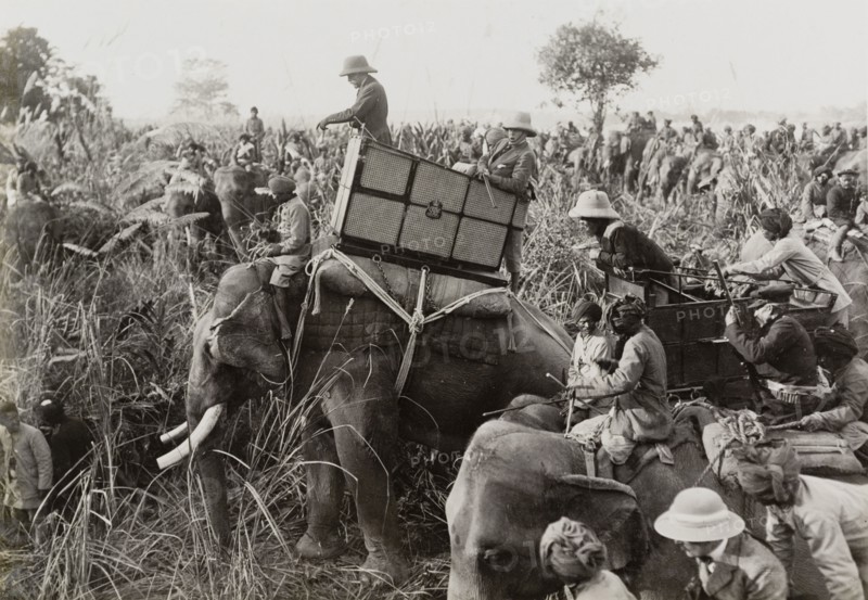 King George V surveys the hunt. King George V (r.1910-36) leans from the howdah on the back of his elephant during a royal hunt in Chitwan Valley hosted by the Maharajah of Nepal. A related image suggests that the King has just shot a tiger. Narayani, Nepal, 18 December 1911., Narayani, Nepal, Southern Asia, Asia.