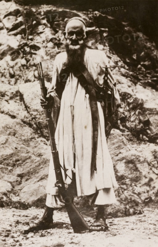 An elderly sniper. Portrait of an elderly man, possibly an Afridi, armed with a rifle and sword. North West Frontier Province, India (Pakistan), circa 1915., North West Frontier Province, Pakistan, Southern Asia, Asia.