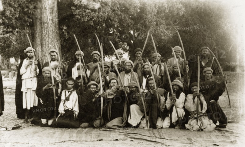 Kafir archers, Pakistan. A group of Kafir archers pose for the camera, their arrows pulled back as if ready to fire. Chitral, North West Frontier Province, India (Pakistan), circa 1915. Chitral, North West Frontier Province, Pakistan, Southern Asia, Asia.