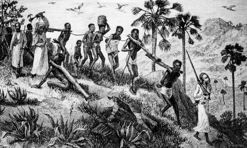 Slavers avenging their losses'. A caravan of African slaves file past a guard who raises his axe to murder one of the weaker captives. The gang are tethered together in pairs by wooden yokes fitted around their necks. Central Africa, circa 1875., Central Africa, Africa.