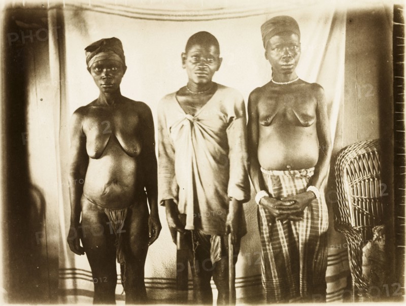 Inhabitants of Bioko. Portrait of a two women and a man from Bioko, posed standing against a makeshift backdrop. Bioko, Equatorial Guinea, circa 1930., Bioko Norte, Equatorial Guinea, Central Africa, Africa.
