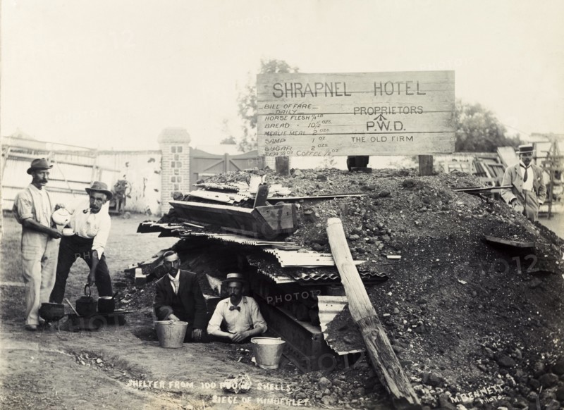 Making tea at the 'Shrapnel Hotel'. British men make tea outside a makeshift bomb shelter, jokingly named 'Shrapnel Hotel'. The shelter was built as protection against the huge shells delivered by 'Long Tom', a type of large gun used by the Boers at the Siege of Kimberley during the Second Boer War (1899-1902). Kimberley, Cape Province (North Cape), South Africa, circa December 1899. Kimberley, North Cape, South Africa, Southern Africa, Africa.