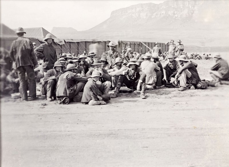 Military compound below the Platberg Mountain. Uniformed British soldiers in the Second Boer War (1899-1902) sit outside a military compound in a valley below the Platberg Mountain. Harrismith, Orange River Colony (Free State), South Africa, circa 1901. Harrismith, Free State, South Africa, Southern Africa, Africa.