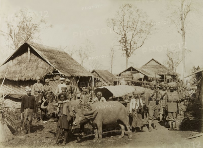 Village at the Morgandine Pass. Armed British and Indian soldiers pose beside a bullock-drawn cart in a village at the Morgandine Pass. Possibly a mix of British Army and Military Police officers, the men were involved in a campaign to suppress Burmese rebels in Wuntho State (today known as the Sagaing Division). Sagaing, Burma (Myanmar), 1891., Sagaing, Burma (Myanmar), South East Asia, Asia.