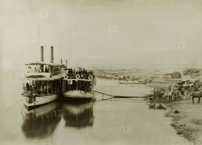 Ferries on the Irrawaddy River. Two ferries containing soldiers from the Second Mountain Battery of the Royal Artillery are moored alongside a sandy bank of the Irrawaddy River. The company was involved in a campaign to suppress Burmese rebels in Wuntho State (Sagaing Division). Htagaing, Burma (Myanmar), circa 1891. Htagaing, Sagaing, Burma (Myanmar), South East Asia, Asia.
