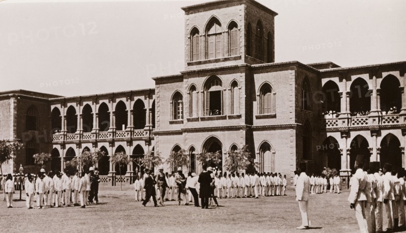 Student inspection at Gordon College, Khartoum. Lines of Sudanese students, dressed in a uniform of white suits and fez hats, wait for an inspection by military officers in a courtyard outside Gordon College. Khartoum, Sudan, circa 1910. Khartoum, Khartoum, Sudan, Eastern Africa, Africa.