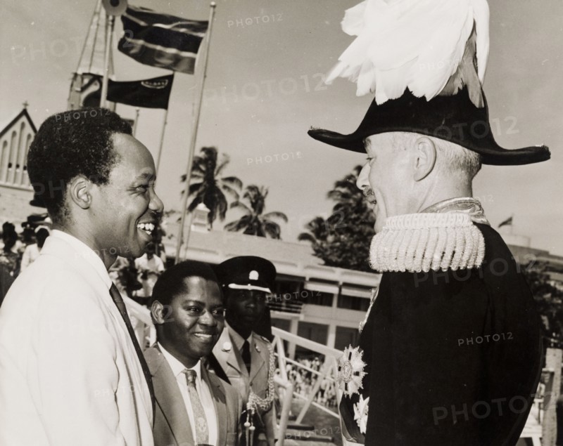 Nyerere and Kawawa say farewell to Sir Richard Turnball. The President of a newly independent Tanzania, Julius Nyerere (1922-1999), and his Prime Minister, Rashid Kawawa (b.1926), bid farewell to Sir Richard Turnbull (1909-1998), the last British colonial Governor of Tanganyika, as he prepares to leave the country. Tanganyika (Tanzania), 8 December 1962. Tanzania, Eastern Africa, Africa.