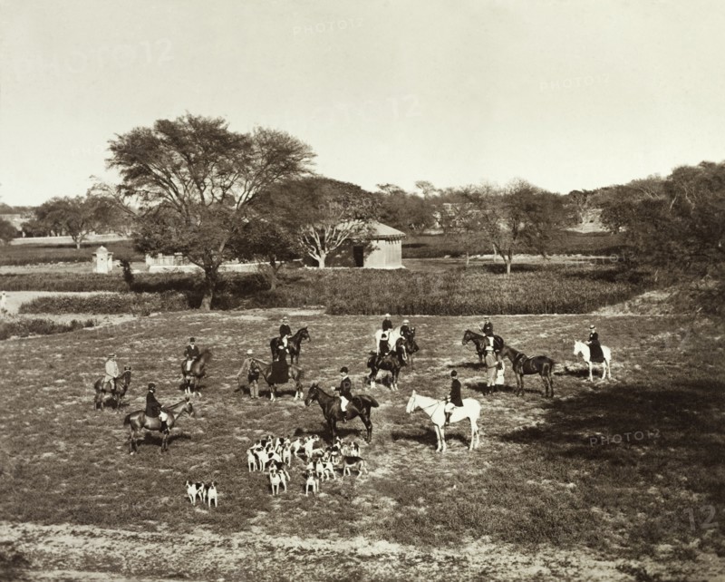 A meet of horses and hounds at Sialkot. A British hunting party gathers for a meet at the start of a English-style hunt in Sialkot. Mounted on horseback, the group comprises men and women, dressed in full riding gear and accompanied by a pack of hunting hounds. Sialkot, Punjab, India (Punjab, Pakistan), 1882. Sialkot, Punjab, Pakistan, Southern Asia, Asia.