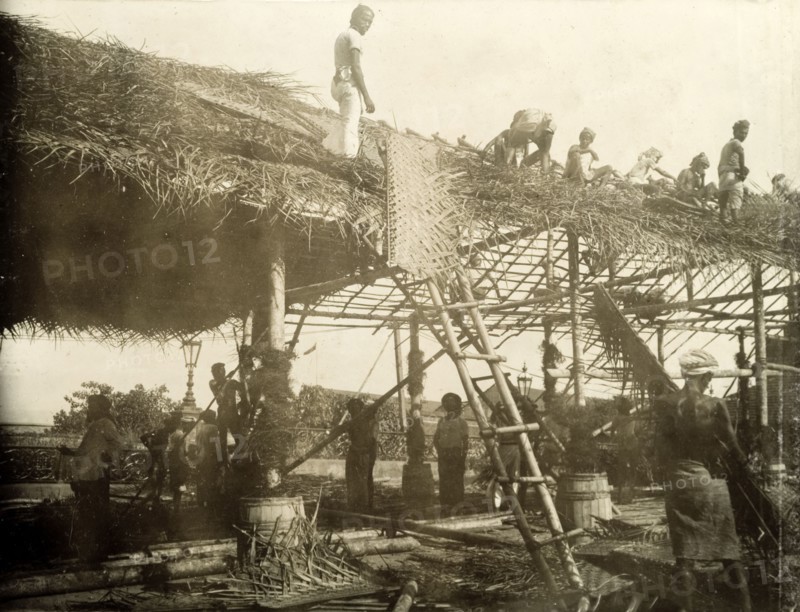 Thatching a roof for the royal visit. A team of Ceylonian men thatch the roof of a spectator stand in preparation for a visit from the Duke and Duchess of Cornwall and York (later King George V and Queen Mary). The royal couple stopped in Ceylon (Sri Lanka) on their way to open the first Commonwealth Parliament of Australia in Melbourne. Colombo, Ceylon (Sri Lanka), April 1901. Colombo, West (Sri Lanka), Sri Lanka, Southern Asia, Asia.