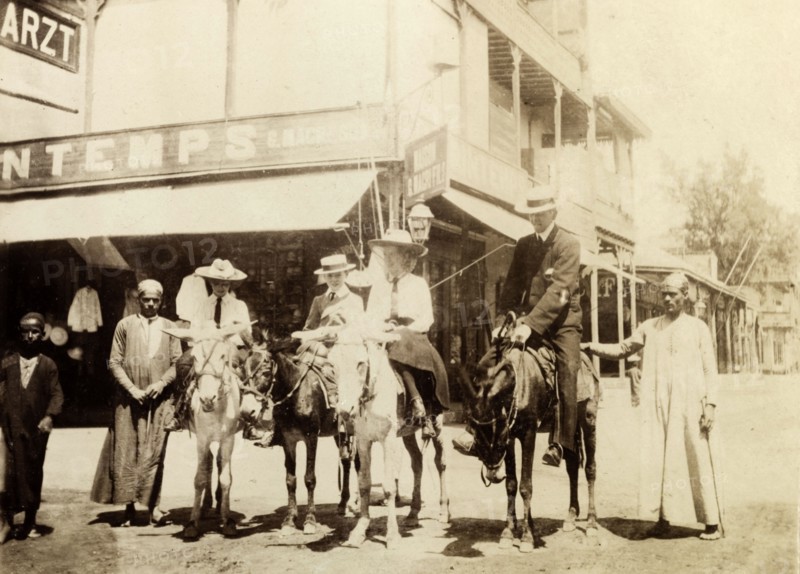 The Lawley children ride donkeys at Port Said. The Lawley children, left to right: Cecilia, 'Ned' (Richard) and Ursula, are supervised by their tutor, Mr. Jose, as they ride donkeys in the centre of town. Port Said, Egypt, circa April 1901. Port Said, Port Said, Egypt, Northern Africa, Africa.