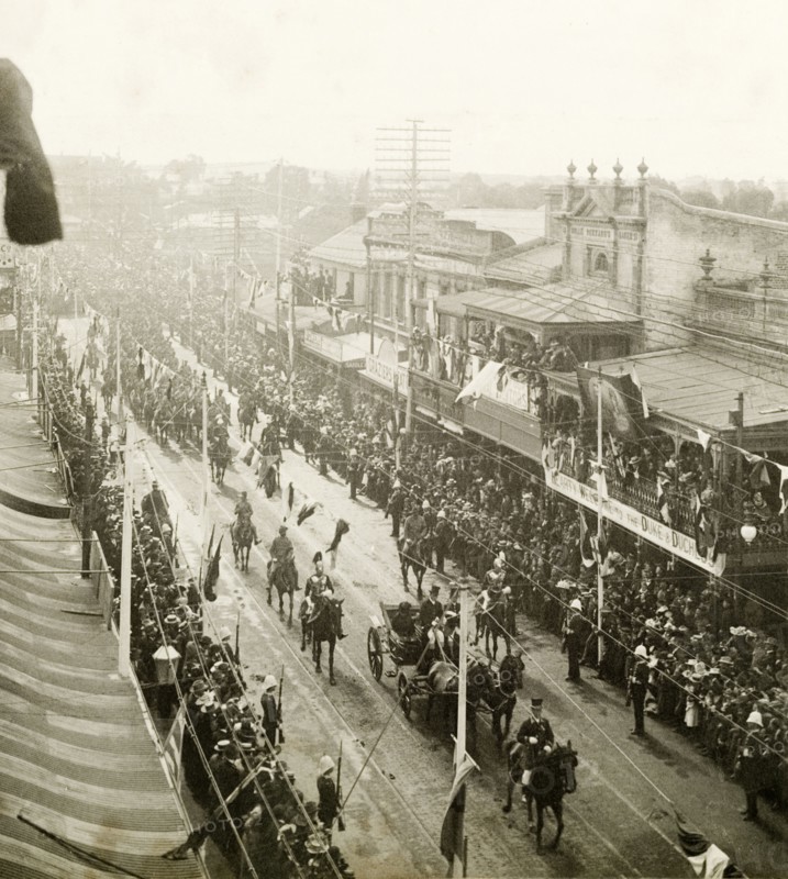 Royal parade through Perth, 1901. A horse-drawn carriage containing the Duke and Duchess of Cornwall and York (later King George V and Queen Mary), parades through the streets of Perth, watched by an eager crowd of spectators who are held back by barriers. Perth, Australia, July 1901. Perth, West Australia, Australia, Australia, Oceania.
