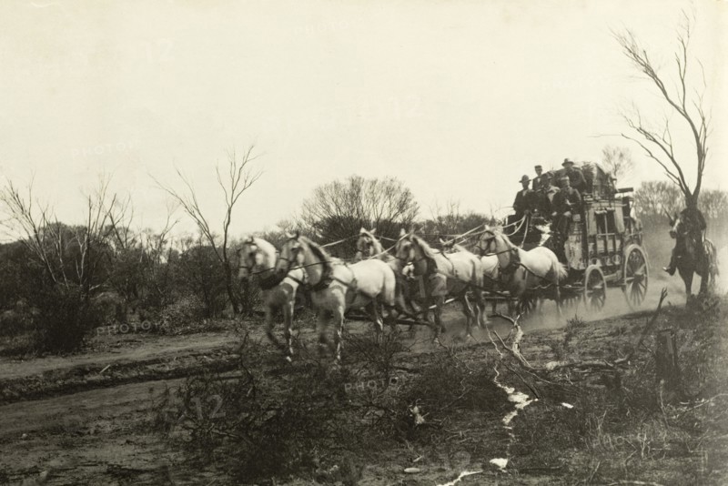 Stage coach travel in the outback. Six horses pull a stage coach full of people along a dirt track in the outback. The coaches were used to transport travellers from one town to another before the arrival of the railroad. Western Australia, Australia, circa 1901., West Australia, Australia, Australia, Oceania.