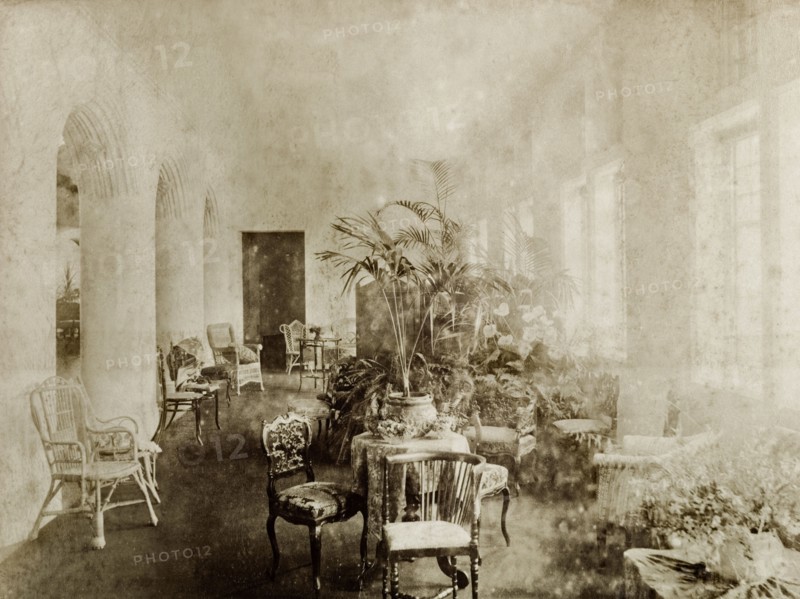 Ballroom seating at Government House, Perth. Interior shot of the ballroom seating area inside Perth's Government House. Wooden and cane chairs are dotted around tables decorated with potted plants. Perth, Australia, circa 1901. Perth, West Australia, Australia, Australia, Oceania.