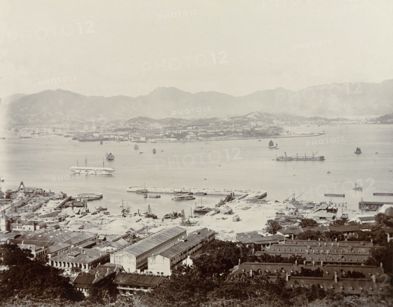 View across Victoria Harbour. A view of Victoria Harbour, taken from Hong Kong Island and overlooking the Kowloon peninsula. A Royal Navy dockyard can be seen off Hong Kong Island, where several ships of the naval fleet are moored. Hong Kong, China, 1903. Hong Kong, Hong Kong, China, People's Republic of, Eastern Asia, Asia.