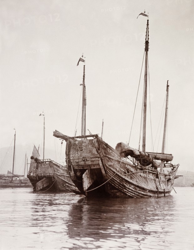 Junks moored at a Hong Kong harbour. Two Chinese junks are moored at a Hong Kong harbour with their rudders raised up out of the water. Hong Kong, China, circa 1903., Hong Kong, China, People's Republic of, Eastern Asia, Asia.