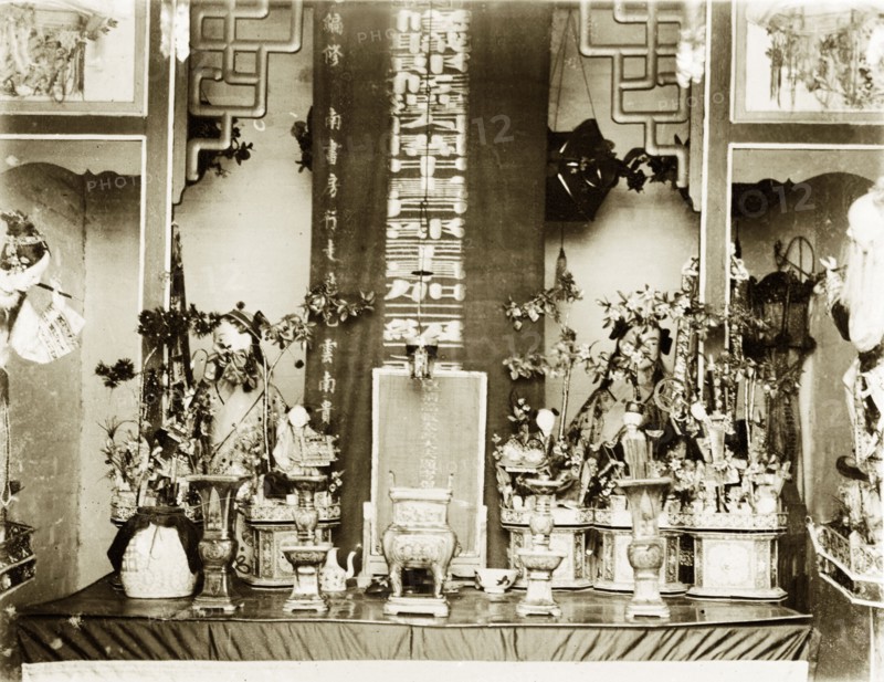 An altar inside a Hong Kong Joss house. An altar inside a Joss house is adorned with religious ornaments including figurines, vases, flowers and texts. Hong Kong, China, circa 1903., Hong Kong, China, People's Republic of, Eastern Asia, Asia.