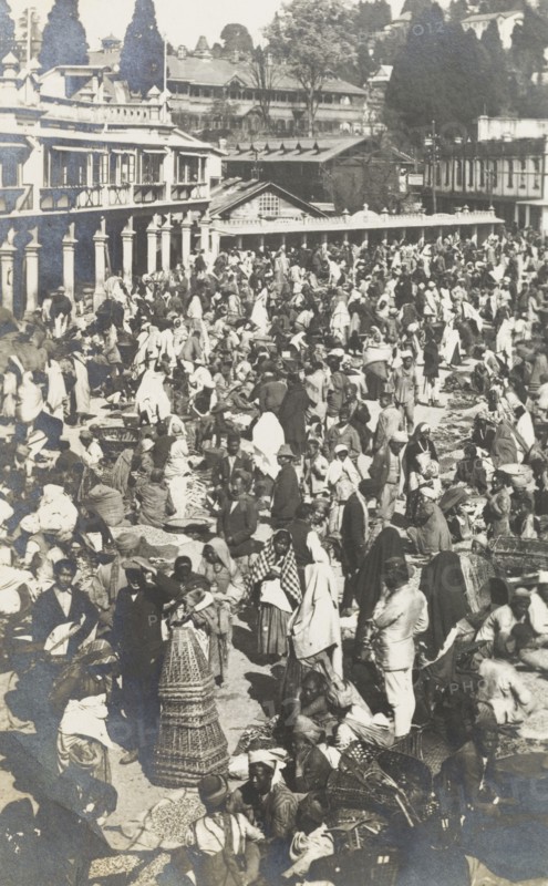 Street bazaar in Darjeeling. Crowds throng a busy street bazaar in Darjeeling. Street traders vie for business, selling goods ranging from baskets to food to customers who weave in and out of the marketplace. Darjeeling, India, circa 1922. Darjeeling, West Bengal, India, Southern Asia, Asia.