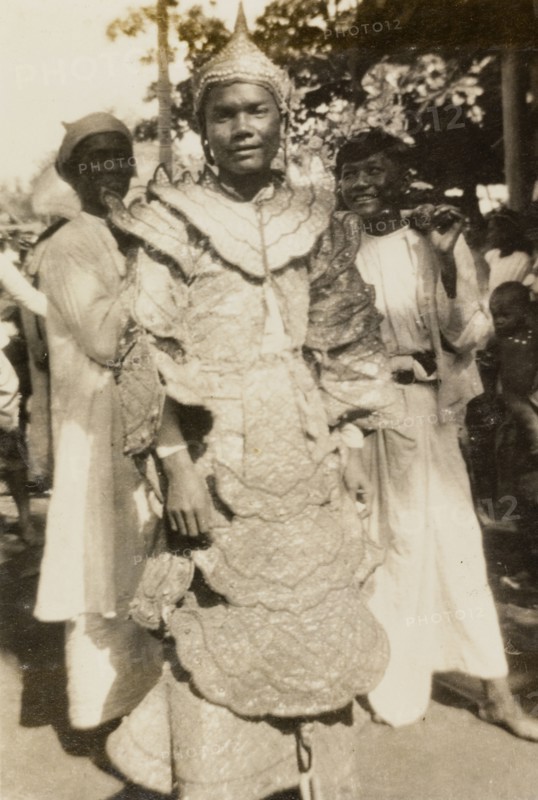 A 'nat kadaw' at the Taungbyon Festival. Portrait of a 'nat kadaw' (spiritual performer), dressed in an elaborate, ruffled costume and pointed hat at the Buddhist Taungbyon Festival. Wagaung, Burma (Myanmar), August 1924. Wagaung, Mandalay, Burma (Myanmar), South East Asia, Asia.