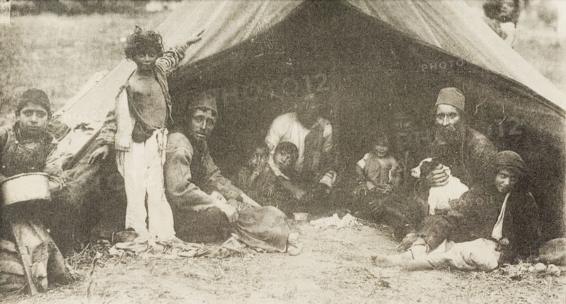 A family of Egyptian nomads. A family of Egyptian nomads, possibly bedouins, gaze at the camera from the entrance of their tent. Egypt, circa 1920. Egypt, Northern Africa, Africa.