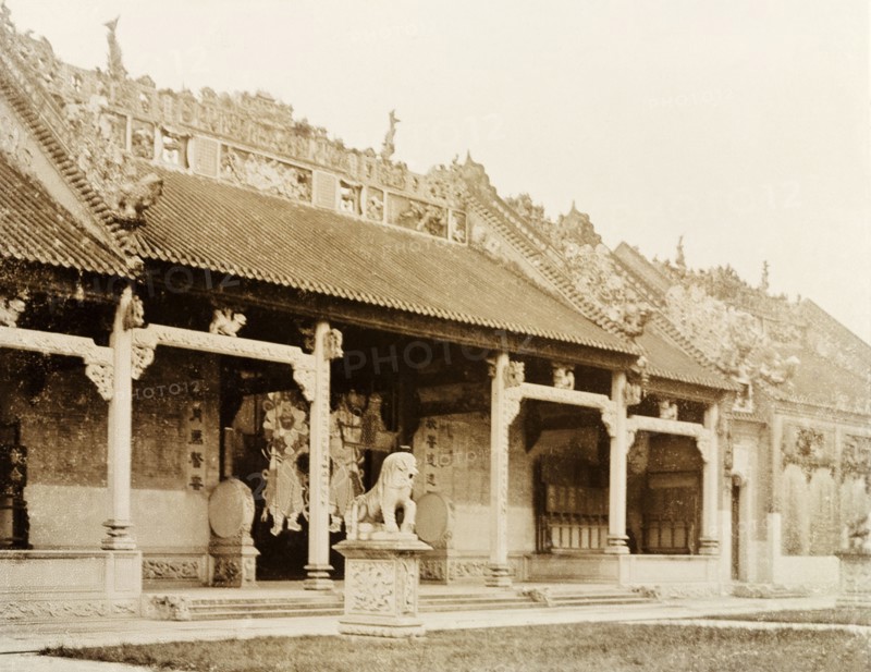 Entrance to a Hong Kong Joss house. Exterior view of a Hong Kong Joss house (Chinese temple). The front entrance of the building is guarded by the statue of a lion: its roof, adorned with decorative stone carvings depicting religious scenes and idols. Hong Kong, China, circa 1905., Hong Kong, China, People's Republic of, Eastern Asia, Asia.