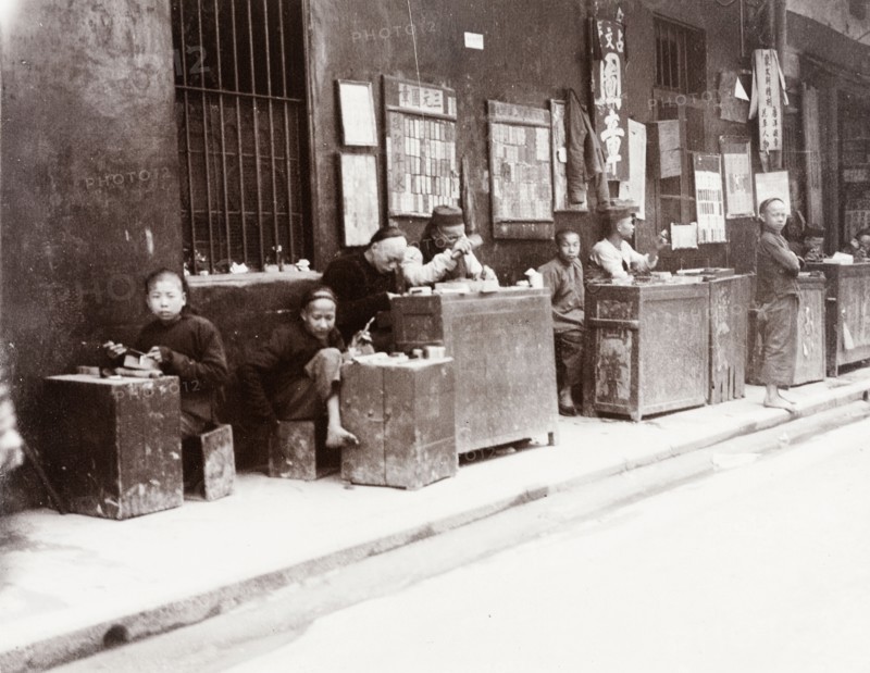 Cantonese seal carvers. A number of Cantonese seal carvers sit at their stalls, waiting for passing business at the side of a city street. Canton, Canton Province (Guangzhou, Guangdong), China, circa 1905. Guangzhou, Guangdong, China, People's Republic of, Eastern Asia, Asia.